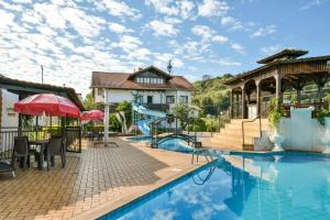a resort with a swimming pool and a playground at Hotel Tirol in Treze Tílias
