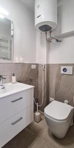 a bathroom with a white toilet and a sink at Borgo Marchetti in Camerano