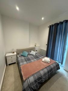 Schlafzimmer mit einem großen Bett und blauen Vorhängen in der Unterkunft Cozy 1 Bed City Escape in Epsom