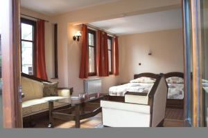 a bedroom with a bed and a table and a couch at Hotel Old Times in Asenovgrad
