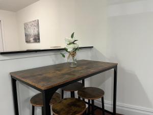 Una mesa con sillas y un jarrón con flores. en Parkline Suites Upper West Side, en Nueva York