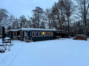 a tiny house in the snow in a yard at Dejligt Sommerhus Tæt Ved Lammefjorden in Kisserup