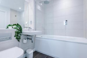 ein weißes Badezimmer mit Waschbecken, Badewanne und Toilette in der Unterkunft Skyline Apartment With Thermal Spa in Manchester + 43 Fotos