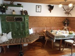 a dining room with a table and a green stove at Ferienwohnung Faschinggut in Rottau +9 photos