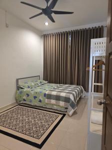 une chambre avec un lit et un ventilateur de plafond dans l'établissement D'Stay Anak Dara Kijal, à Kijal