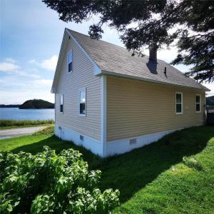 a small house on the side of a lake at Seaside Serendipity Cottage in Herring Neck