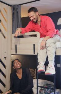 a man sitting on a bunk bed next to a woman at Whoo Bordeaux Bacalan - Hostel in Bordeaux