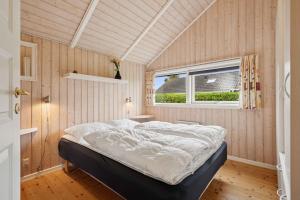 une chambre avec un lit dans une pièce avec une fenêtre dans l'établissement Beachside Holiday Home For The Whole Family, à Broager