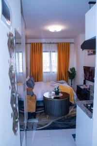 a bedroom with a bed and a couch and a table at Luxore Apartments Syokimau No E311 in Nairobi +26 photos