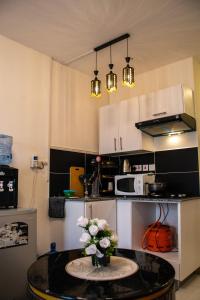 a kitchen with a table with a vase of flowers on it at Luxore Apartments Syokimau No E311 in Nairobi