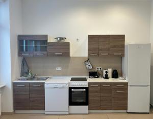 a kitchen with a white stove and a refrigerator at Petit Chatelet Rooms in Saarbrücken