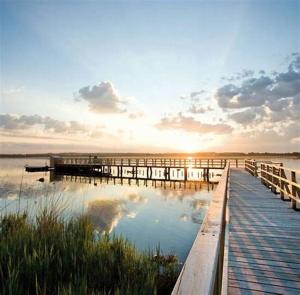 - un quai sur une étendue d'eau au coucher du soleil dans l'établissement FeWo Relaxfit, à Bad Buchau