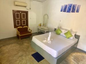 Un dormitorio con una cama, una silla y un espejo. en Avalon Villa Unawatuna, en Unawatuna
