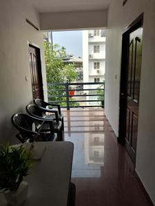 a room with chairs and a table and a balcony at Vidara Budget Stay in Trivandrum