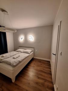 - une chambre avec un lit et deux lumières sur le mur dans l'établissement Teatralna Nowoczesny Apartament Centrum Bolesławca, à Bolesławiec