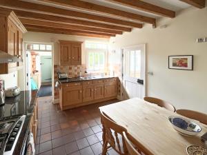 eine Küche mit Tisch und eine Küche mit Herd in der Unterkunft The Old Coach House in York