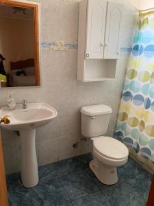 a bathroom with a toilet and a sink at Inmobiliaria in La Laguna Zapallar +2 photos