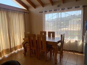 a dining room with a table and chairs and a window at Inmobiliaria in La Laguna Zapallar
