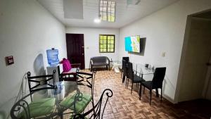 a room with chairs and a person sitting at a table at Peace N' Green - APARTMENTS - Sosa&Barbero in David