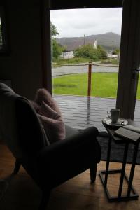 a living room with a chair and a table and a window at Quiet Skye Winter hideaway Moluag in Portree