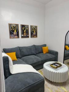 a living room with a blue couch and yellow pillows at Serene luxe homes in Thika