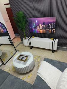 a living room with a tv and a white couch at Serene luxe homes in Thika