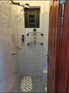 a bathroom with a shower with a mirror and a window at Serene luxe homes in Thika