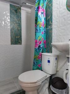 a bathroom with a toilet and a shower curtain at VaRI in Tocaima