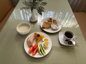 ein Tisch mit zwei Tellern Essen und einer Tasse Kaffee in der Unterkunft Green Hotel in Almaty