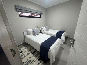 two beds in a small room with a window at Durbanville Daydream in Durbanville