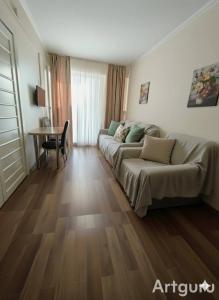 ein Wohnzimmer mit Sofa und Tisch in der Unterkunft მგზავრები Mgzavreni IV აპარტამენტი Apartment 205 in Itʼkhvisi