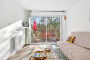un soggiorno con un divano e un tavolo di vetro di Cap à Gap T2 Bas De Villa a Gap