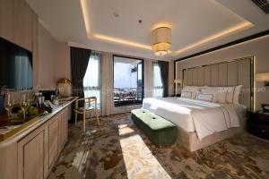 a large bedroom with a large bed and a kitchen at The Haron Hanoi Boutique Hotel in Hanoi