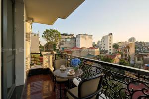 a balcony with a table and chairs and a view at The Haron Hanoi Boutique Hotel in Hanoi
