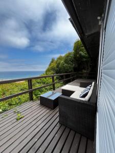 einen Balkon mit einem Bett und Stühlen auf einer Terrasse in der Unterkunft Casa en algarrobo con hermosa vista al mar in Algarrobo