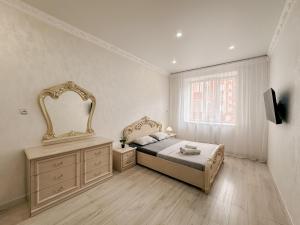 a bedroom with a bed and a mirror on the wall at 2х комнатная квартира в ЖК Ирина in Pavlodar