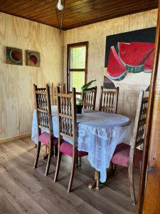 ein Esszimmer mit Tisch und Stühlen und einem Gemälde in der Unterkunft Casa en algarrobo con hermosa vista al mar in Algarrobo
