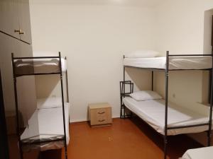 a room with three bunk beds and a box at cozy haven hostel in Aghk'ilisa