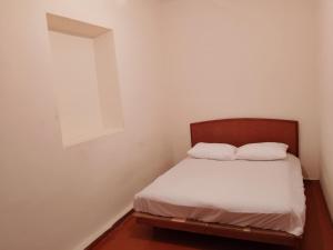a small bedroom with a bed with two pillows at cozy haven hostel in Aghk'ilisa +1 photo