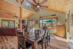 comedor y sala de estar con mesa de madera y sillas en Camp Dancing Bears - Wifi, Riverfront, Pet Friendly, Fire Pit, Grill, Deck, Fishing, Games, Fireplace, King Bed, en Morton Grove