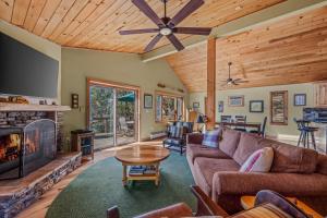 Una sala de estar con un sofá y una chimenea. en Camp Dancing Bears - Wifi, Riverfront, Pet Friendly, Fire Pit, Grill, Deck, Fishing, Games, Fireplace, King Bed, en Morton Grove