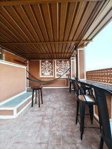 斋浦尔Hammock Hostels - Jaipur的配有桌椅和木制天花板的客房