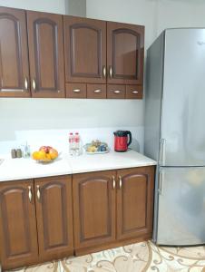 a kitchen with wooden cabinets and a refrigerator at Mladost the City of Fountains Vitosha View in Sofia