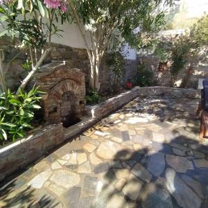 d'un patio en pierre avec une cheminée en pierre dans la cour. dans l'établissement Πέτρινη αυλή, Αρμενιστης Ικαρια, à Armenistis