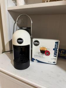 eine Kaffeemaschine auf einer Theke neben einer Schachtel in der Unterkunft Appartamento nel centro di Cassino in Cassino + 24 Fotos