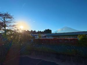 a view of a mountain with the sun in the sky at FUJI Forest House203 in Gotemba +6 photos