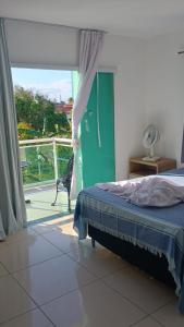 a bedroom with a bed and a door to a balcony at Araruama junto a Lagoa - Centro in Araruama +59 photos
