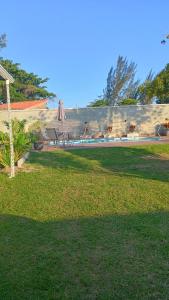 a yard with a fence and a table and an umbrella at Araruama junto a Lagoa - Centro in Araruama