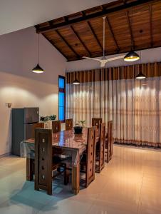 a dining room with a wooden table and chairs at Nirosha Guest House in Galle