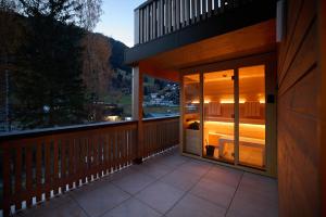 a balcony of a house with a glass door at Die Monika Aparthotel in Gaschurn